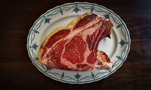 Picture of a bone-in ribeye steak with rib cap lifter meat