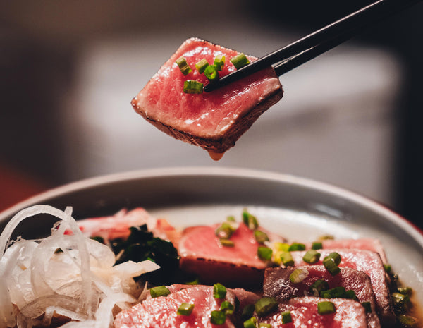 Picture of a Wagyu piece picked up with chopsticks